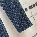 Louis Vuitton pants leg detail, dark blue patterned fabric close-up