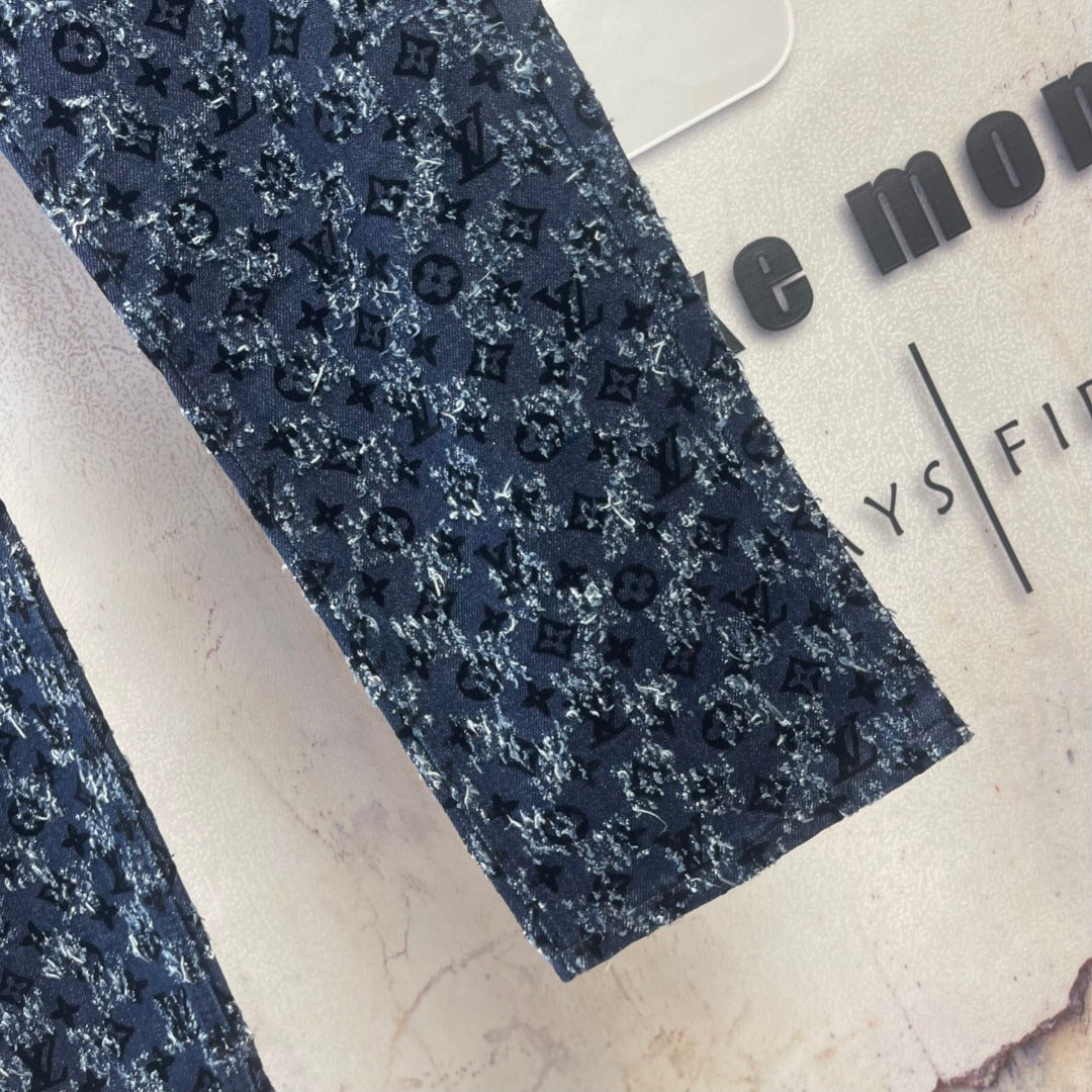Louis Vuitton pants leg detail, dark blue patterned fabric close-up