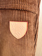 Corduroy pants patch detail with stitched emblem