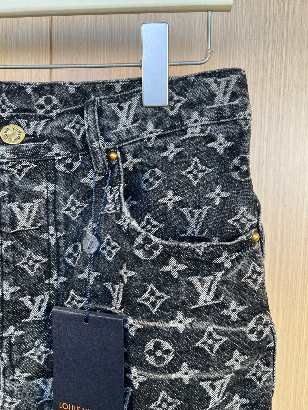 Louis Vuitton pants detail: denim button waist, front pocket with monogram pattern