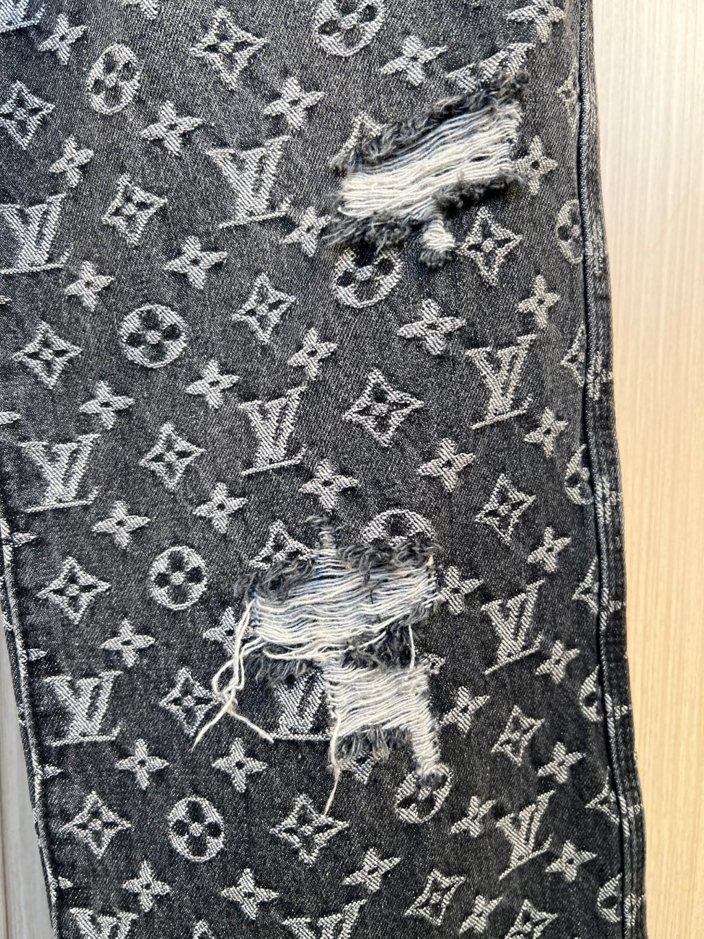 Louis Vuitton pants close-up showing monogram print and distressed embroidered patch