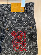 Louis Vuitton pants detail with red embroidered logo on monogram denim, buttoned pockets