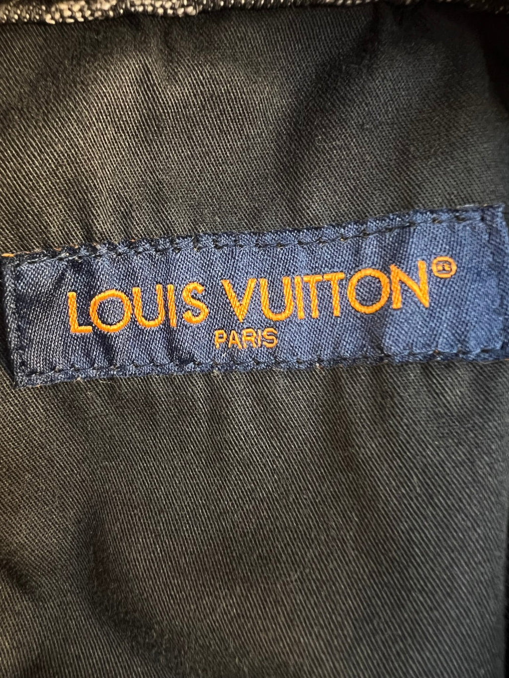 Louis Vuitton pants brand label on inner waistband, blue fabric with yellow text