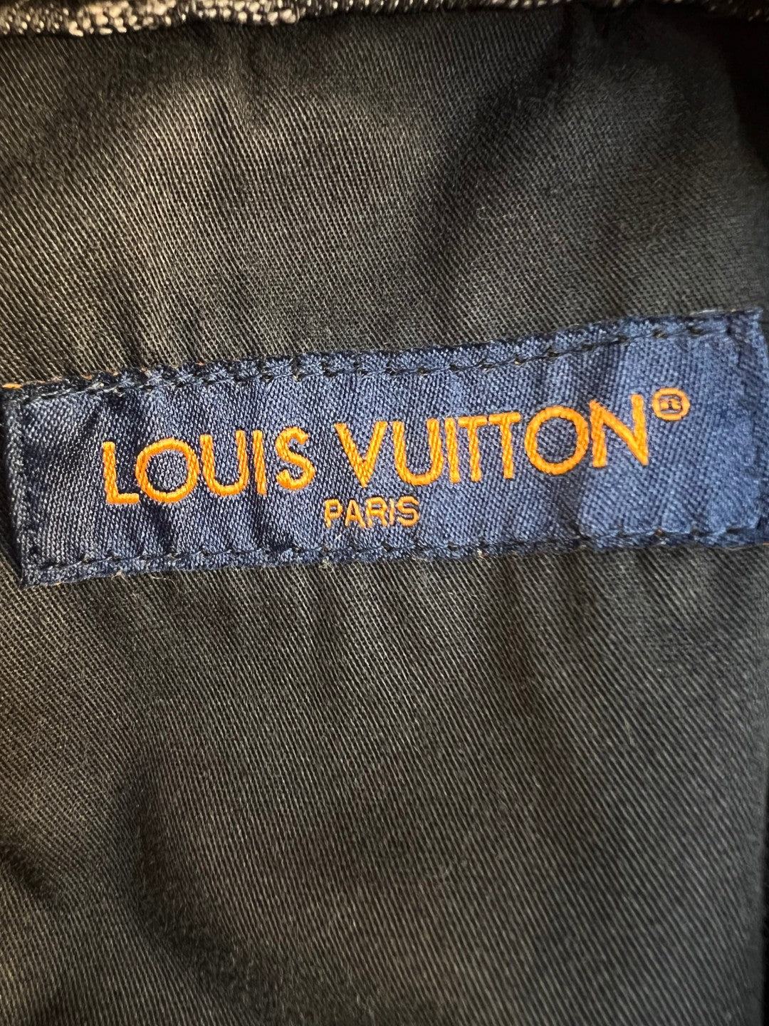 Louis Vuitton pants brand label on inner waistband, blue fabric with yellow text