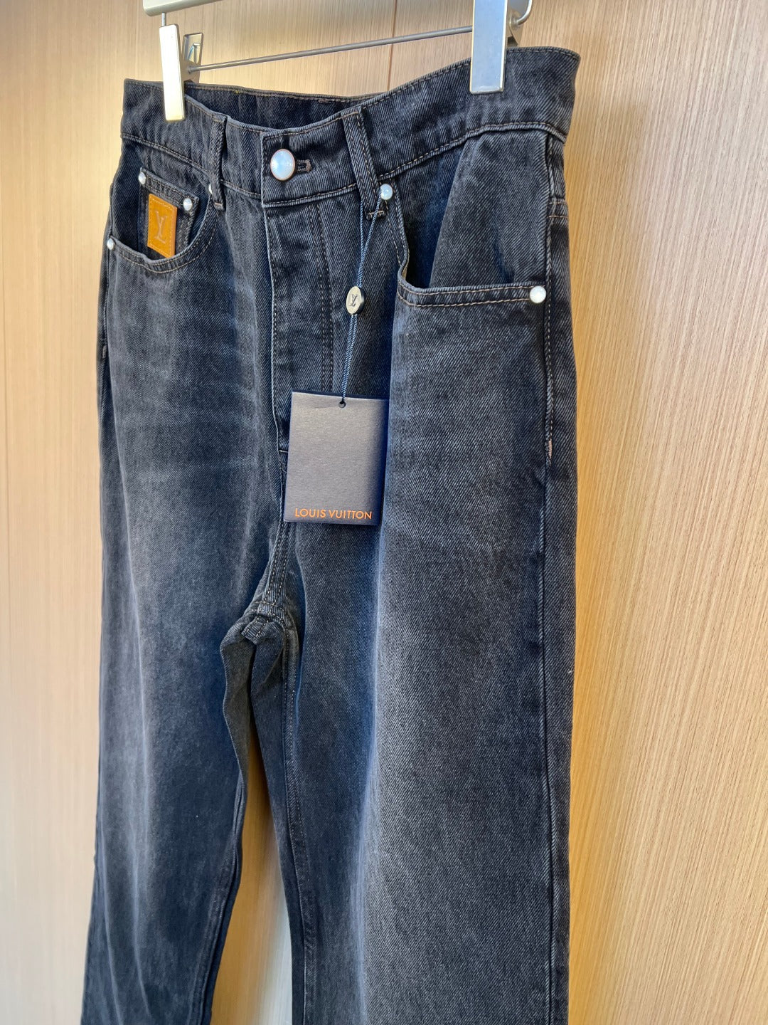 Dark denim pants hanging display with front and coin pocket panels.