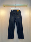 Dark denim pants with front pockets and LV logo patch at hip.