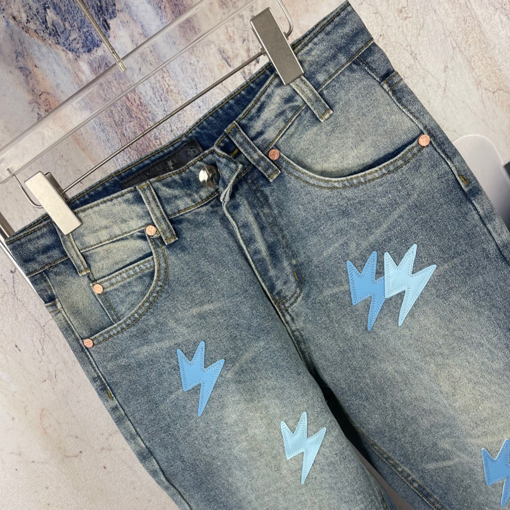 Light blue denim jeans with waistband and light blue lightning patches, angled view