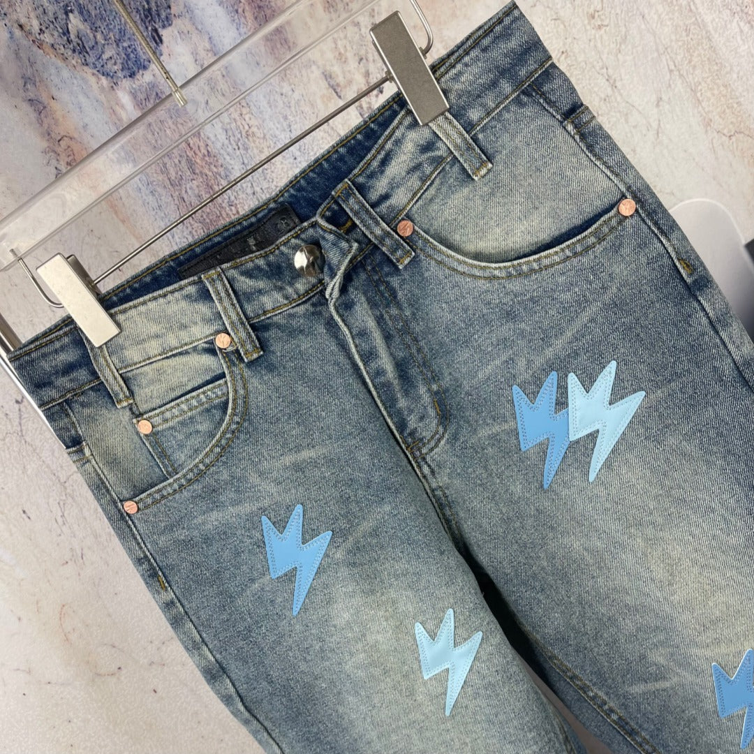 Light blue denim jeans with waistband and light blue lightning patches, angled view