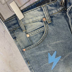 Light blue denim jeans front with brass buttons and light blue lightning patch