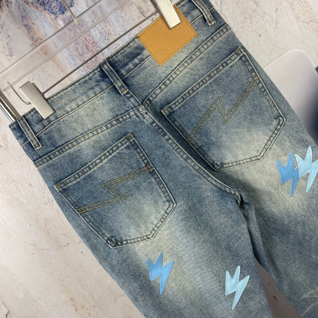 Light blue denim jeans back pockets with light blue lightning patches, folded view