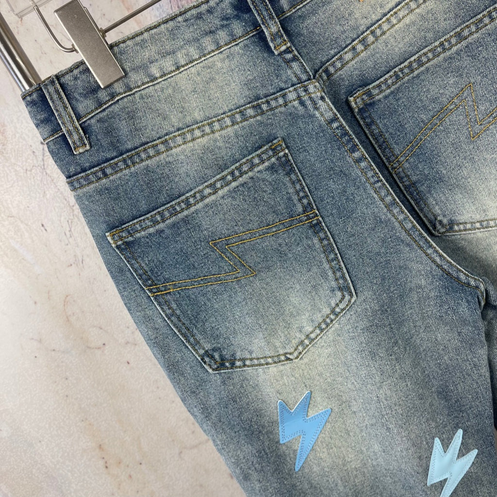 Light blue denim jeans back pocket and belt loops with lightning patch detail