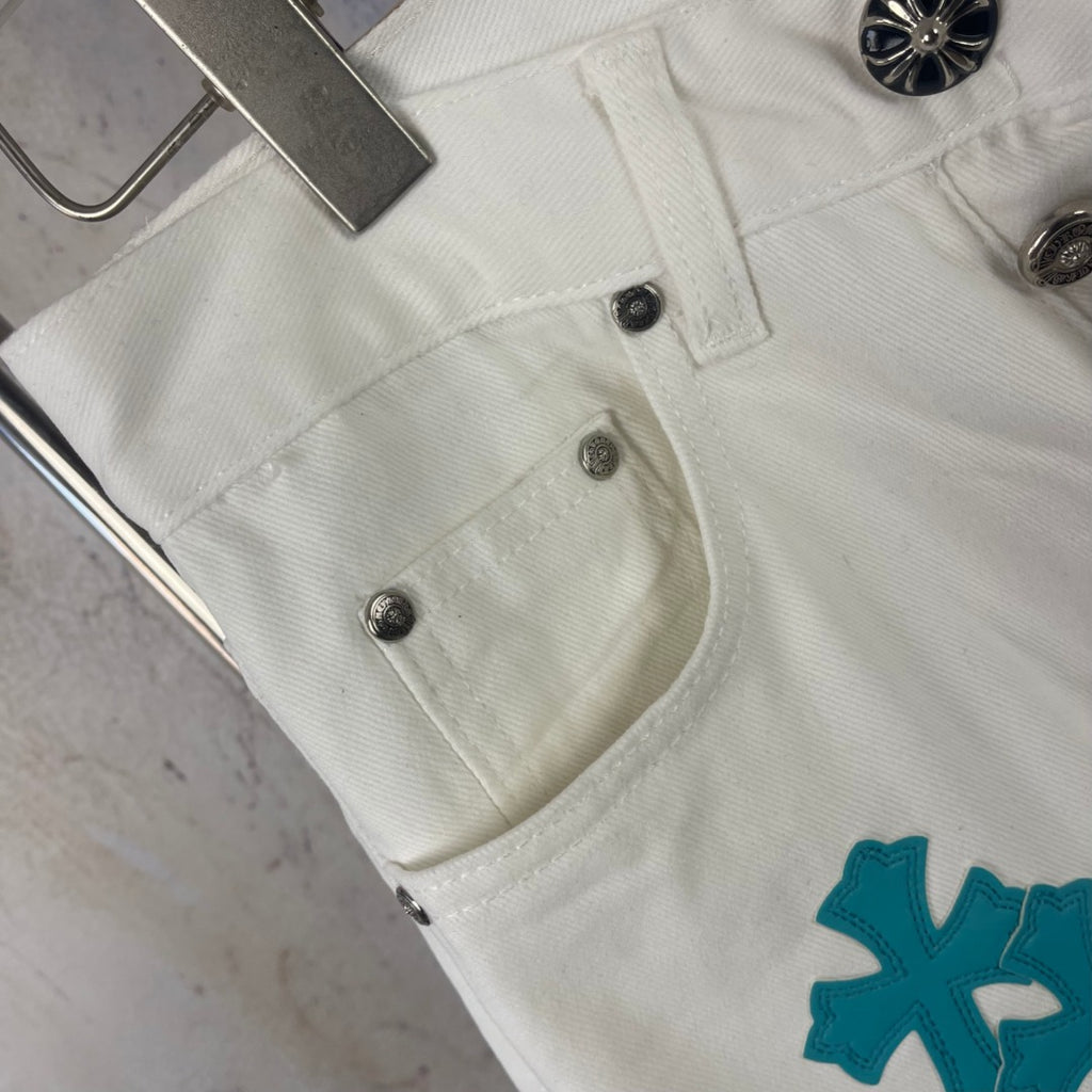 White denim pants front pocket with metal buttons and teal logo patch