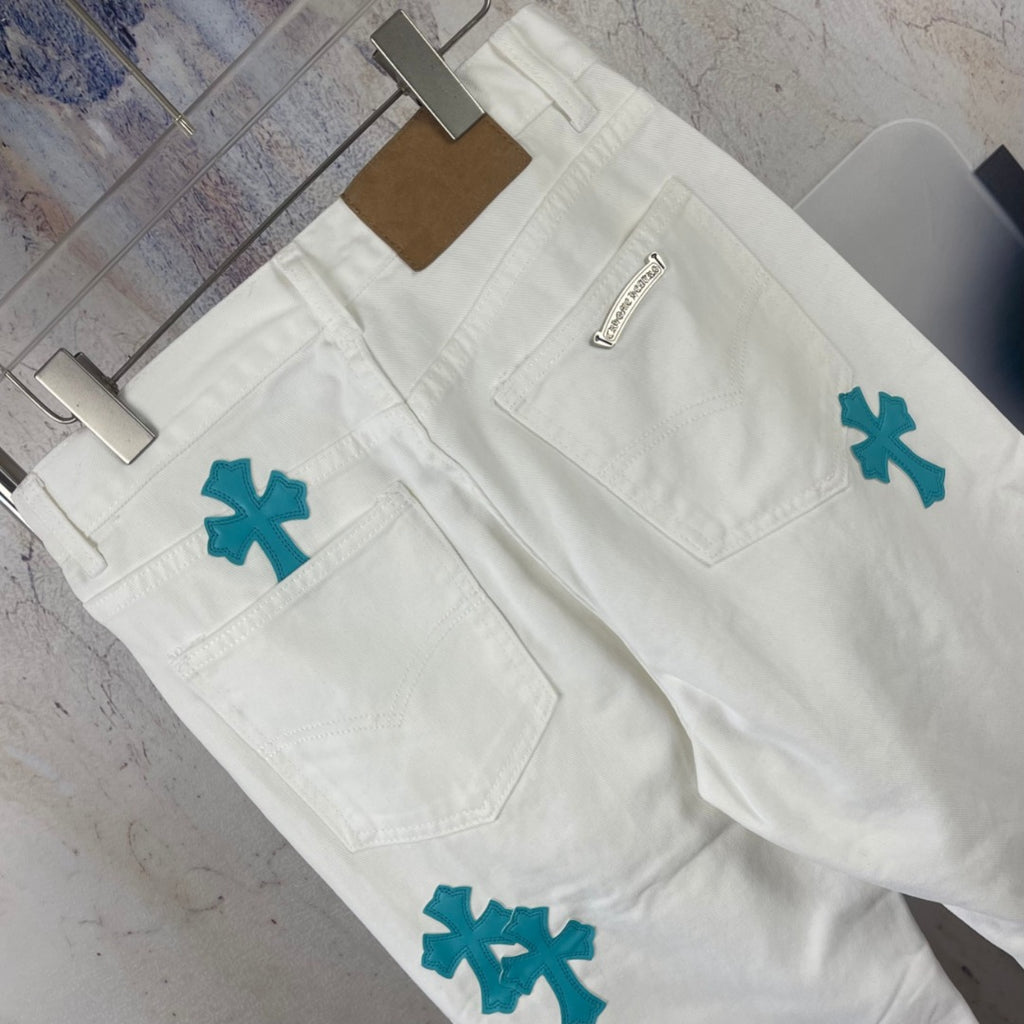 White denim jeans with teal cross patches and small stitched label