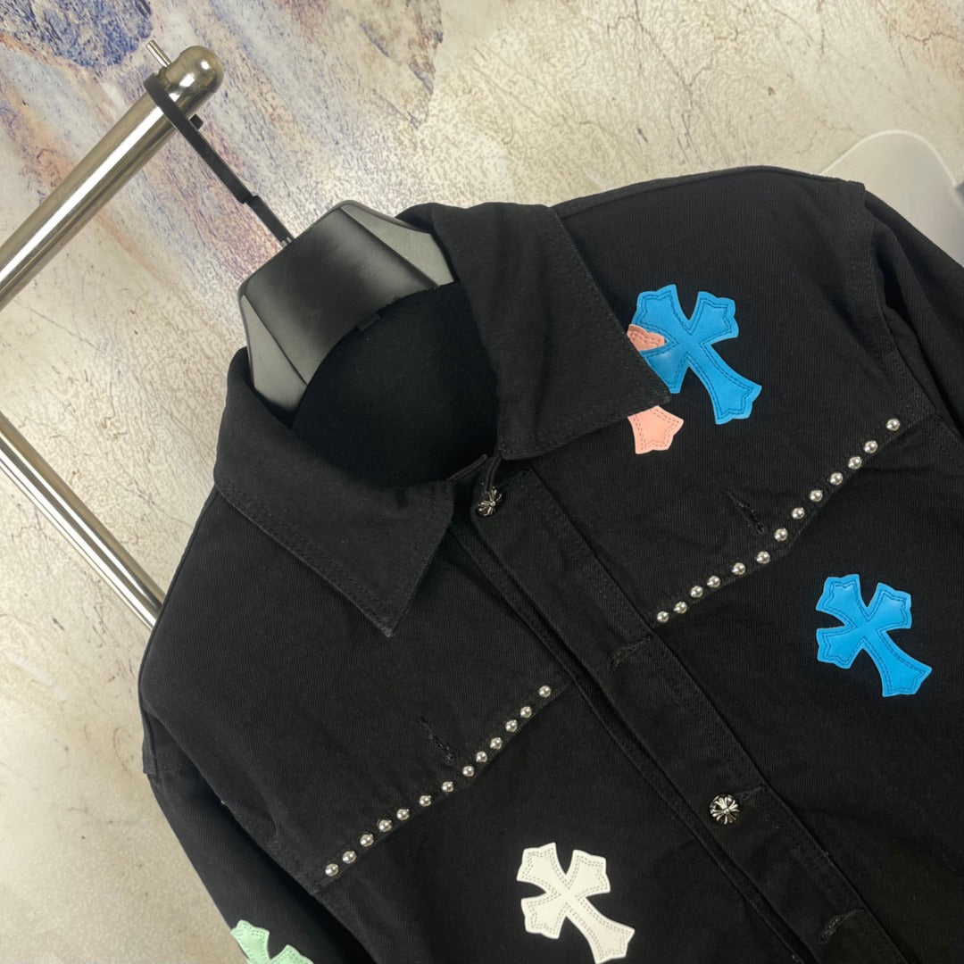 Black long-sleeve denim jacket with blue and white cross appliques and stud trim