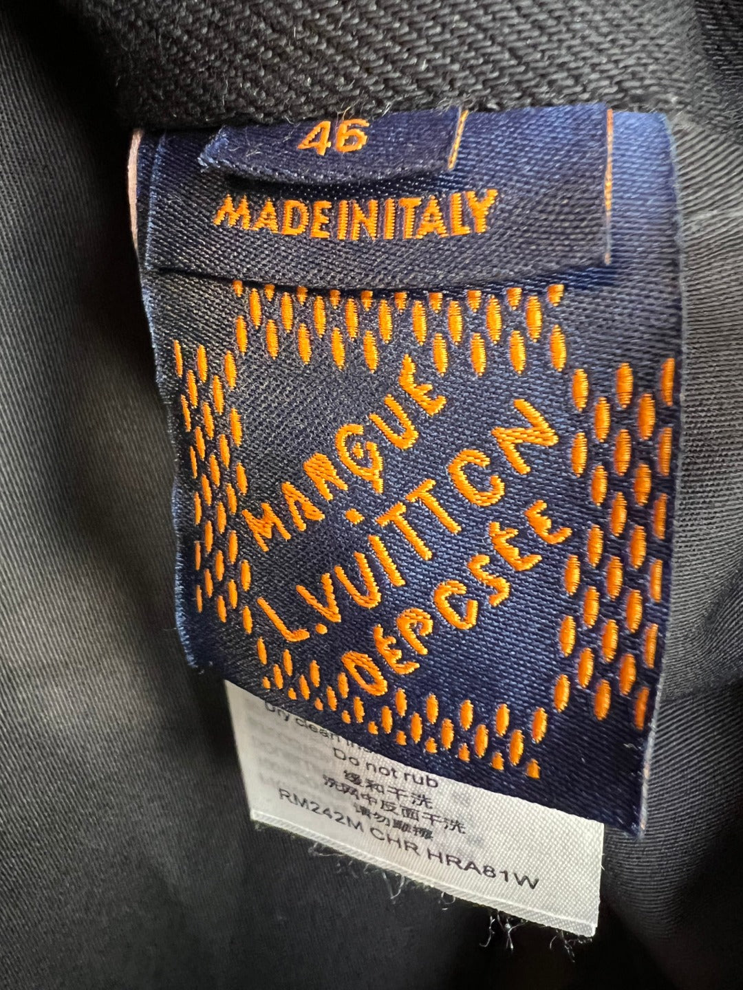 Inside neck label on dark denim jacket reading “Made in Italy” and size 46.