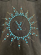 Dark denim jacket back with circular starburst rhinestone and stud pattern in blue.