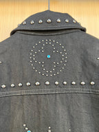 Dark denim jacket back yoke with studded diamond motif and blue rhinestone dot.