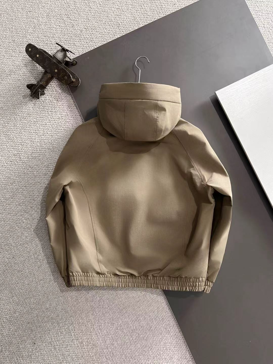 Lightweight hooded jacket in tan, back view with attached hood and elastic hem