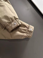 Lightweight hooded jacket cuff with buttoned tab and gathered elastic hem