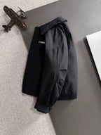 Dior long black jacket on hanger with structured shoulders and snap front closure