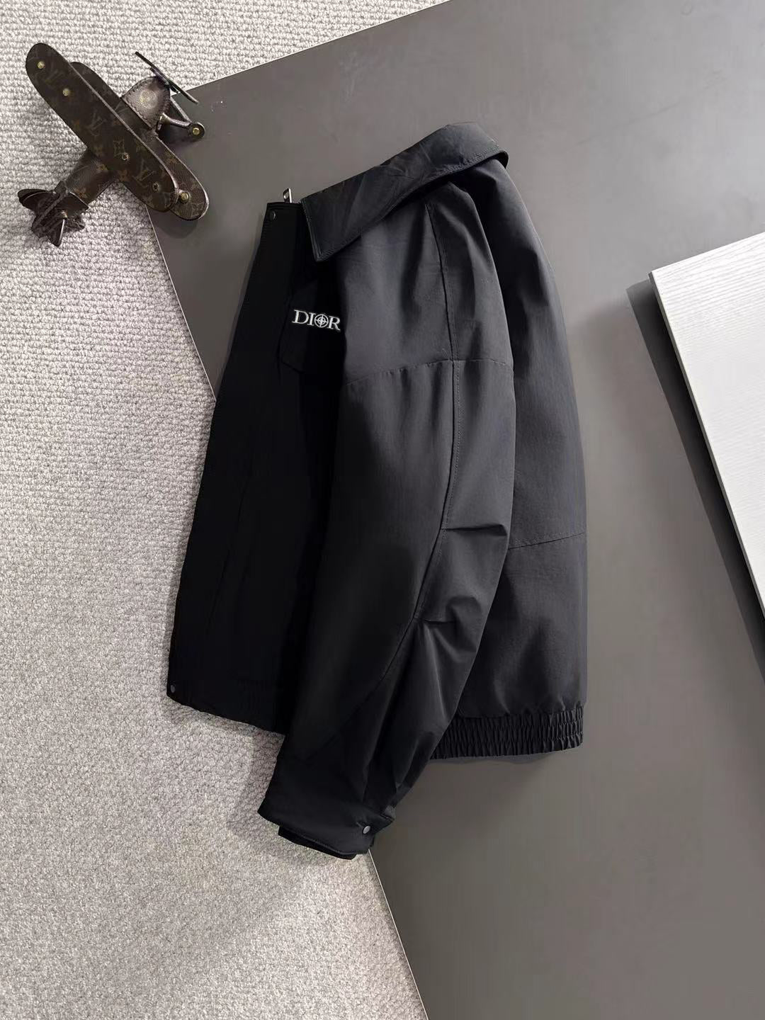 Dior long black jacket on hanger with structured shoulders and snap front closure