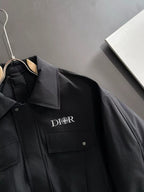 Dior long black jacket front close-up with chest logo and snap pockets