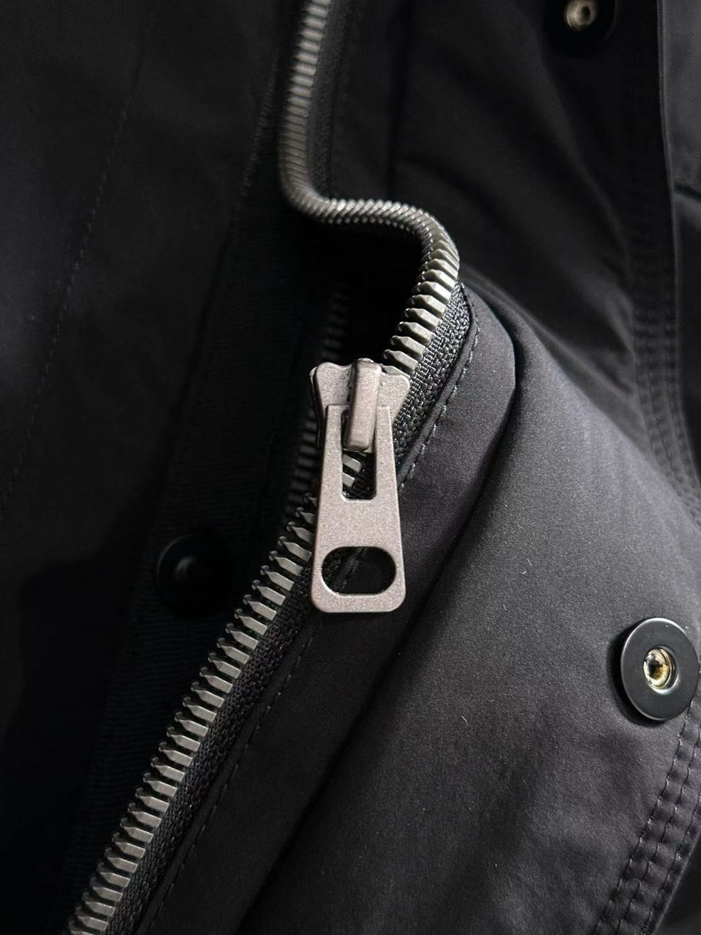 Dior long black jacket detail with front zipper, snap placket, and metal buttons