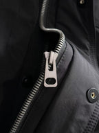 Dior long black jacket detail with front zipper, snap placket, and metal buttons