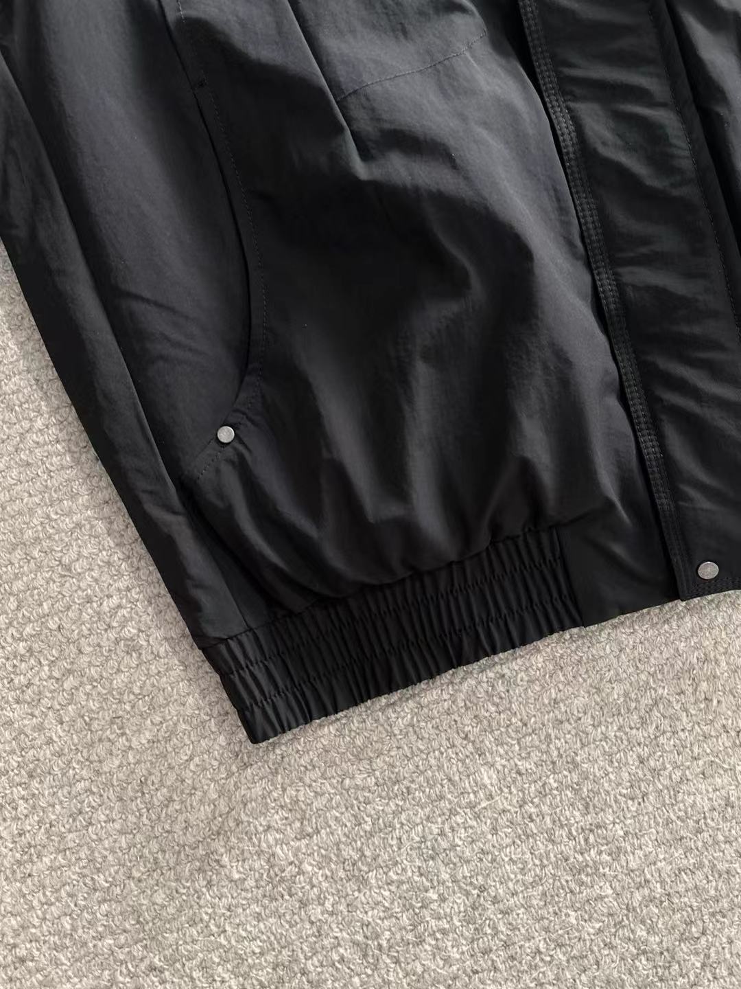 Dior long black jacket lower hem with gathered elastic and snap front details