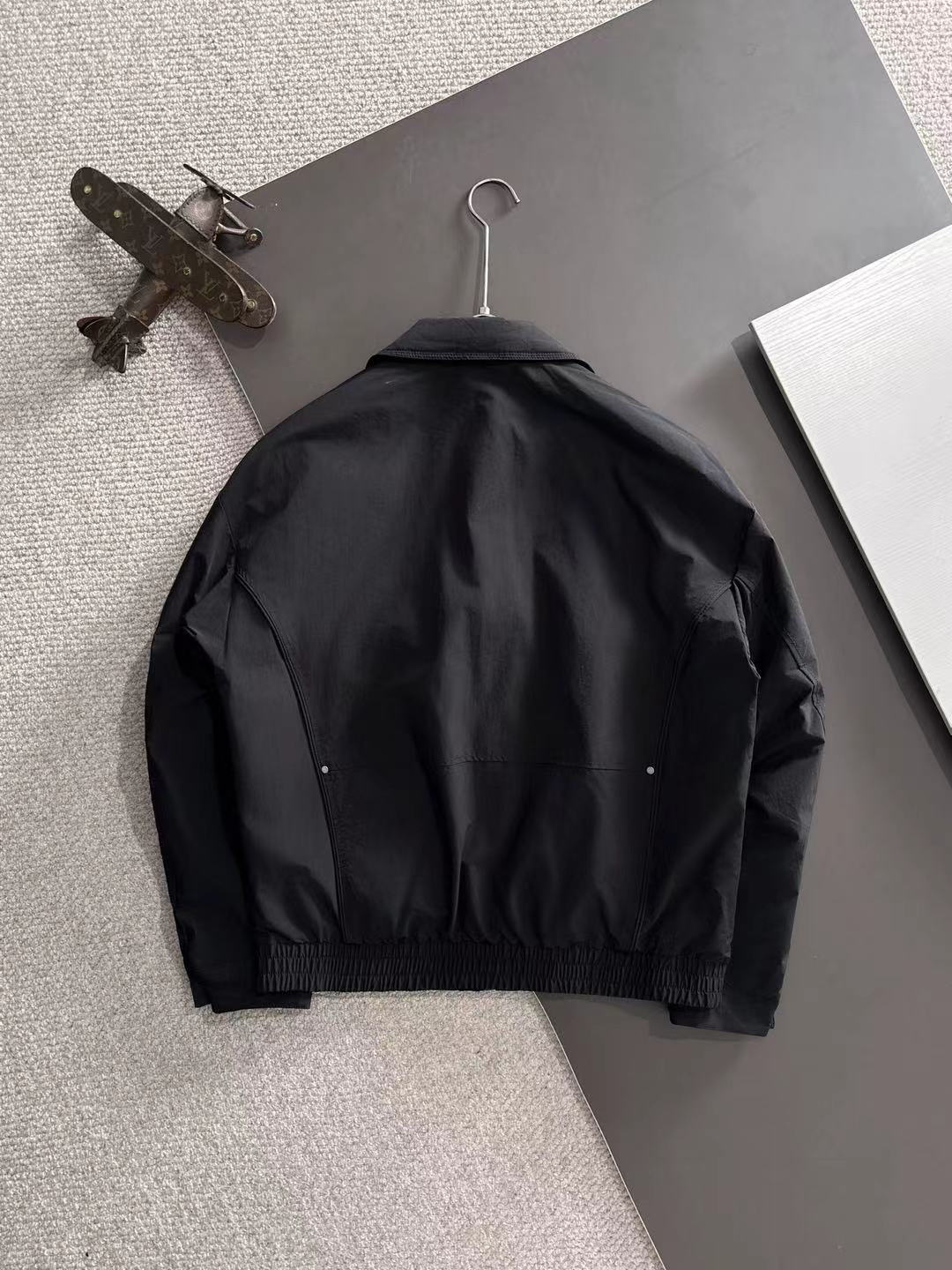 Dior long black jacket back view with button details and elastic hem