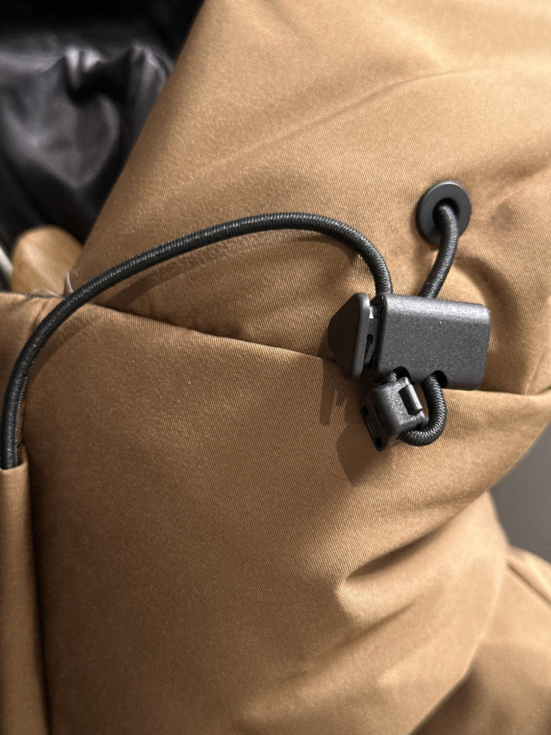 Moncler puffer jacket close-up of cord pull tab and matte fabric hood