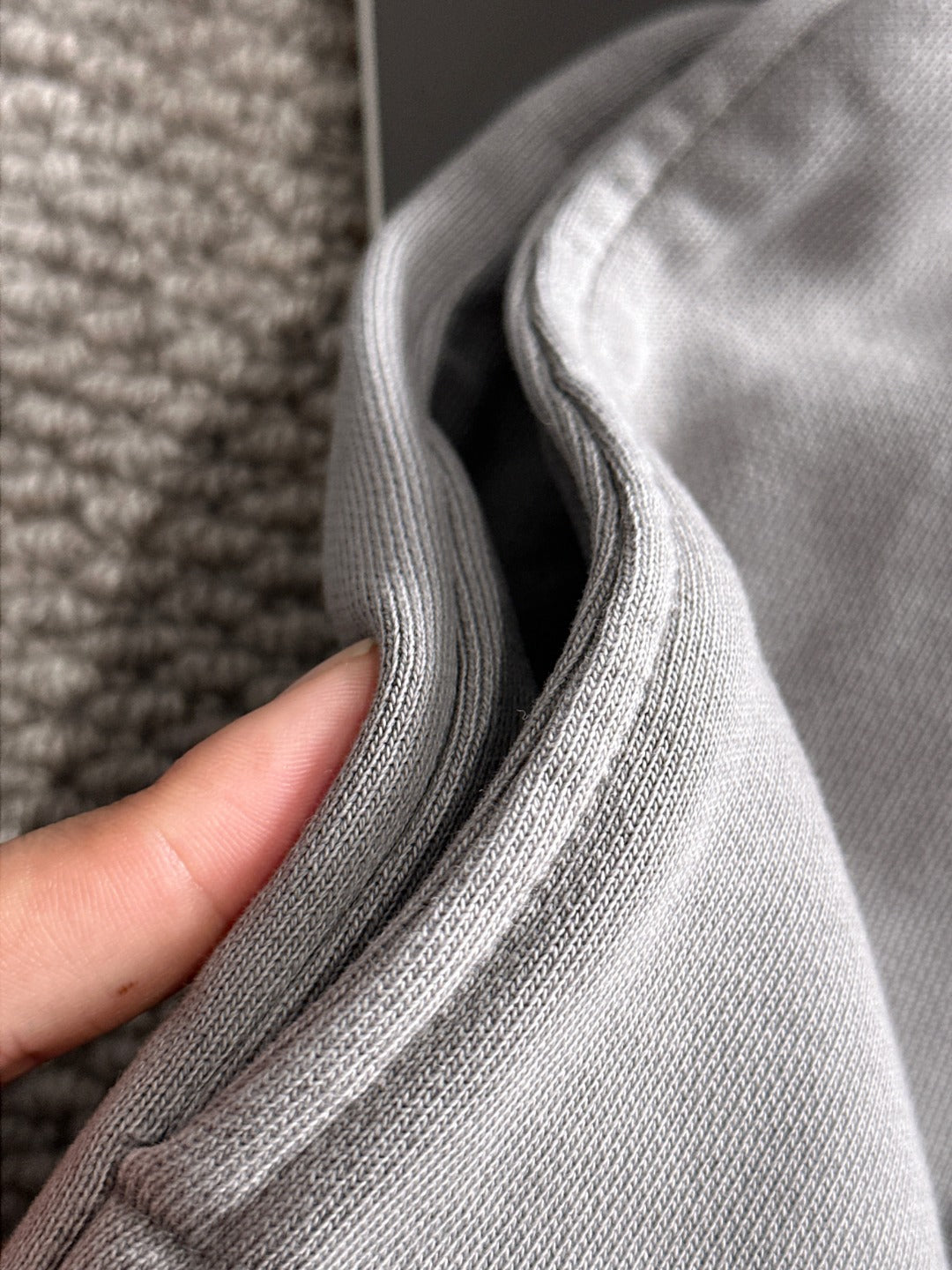 Stone Island light gray knit fabric close-up with ribbed seam and texture