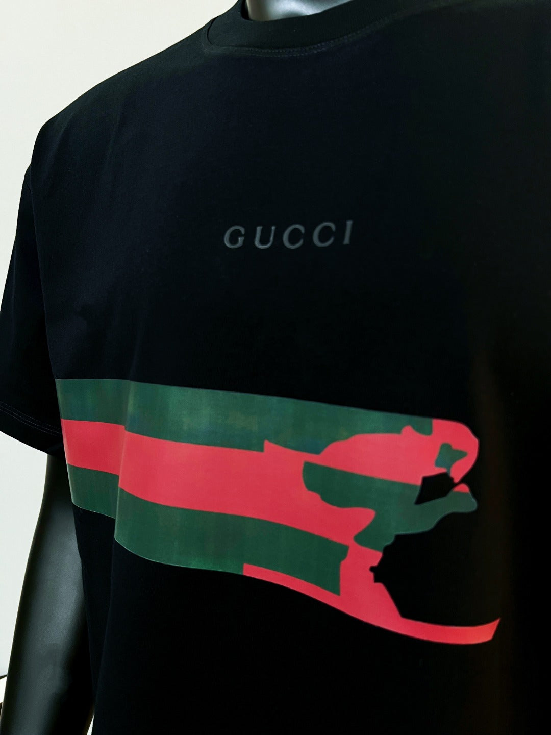 Black Gucci T-shirt with red and green graphic stripe and standing figure print