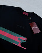 Black Gucci T-shirt neckline with button and red-green graphic stripe across chest