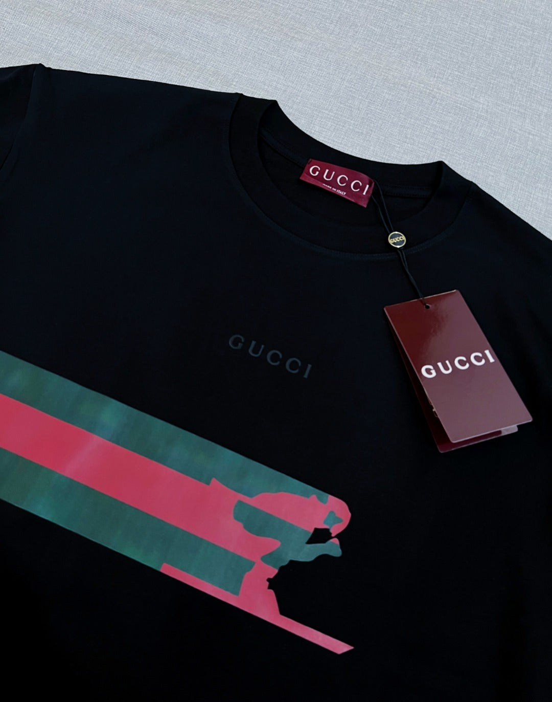 Black Gucci T-shirt neckline with button and red-green graphic stripe across chest
