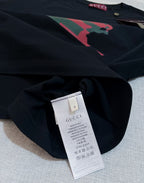 Black Gucci T-shirt fabric close-up with size label at inner neckline