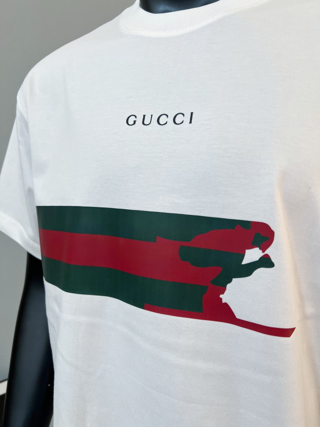 White Gucci T-shirt front with “GUCCI” logo and red/green animal stripe graphic