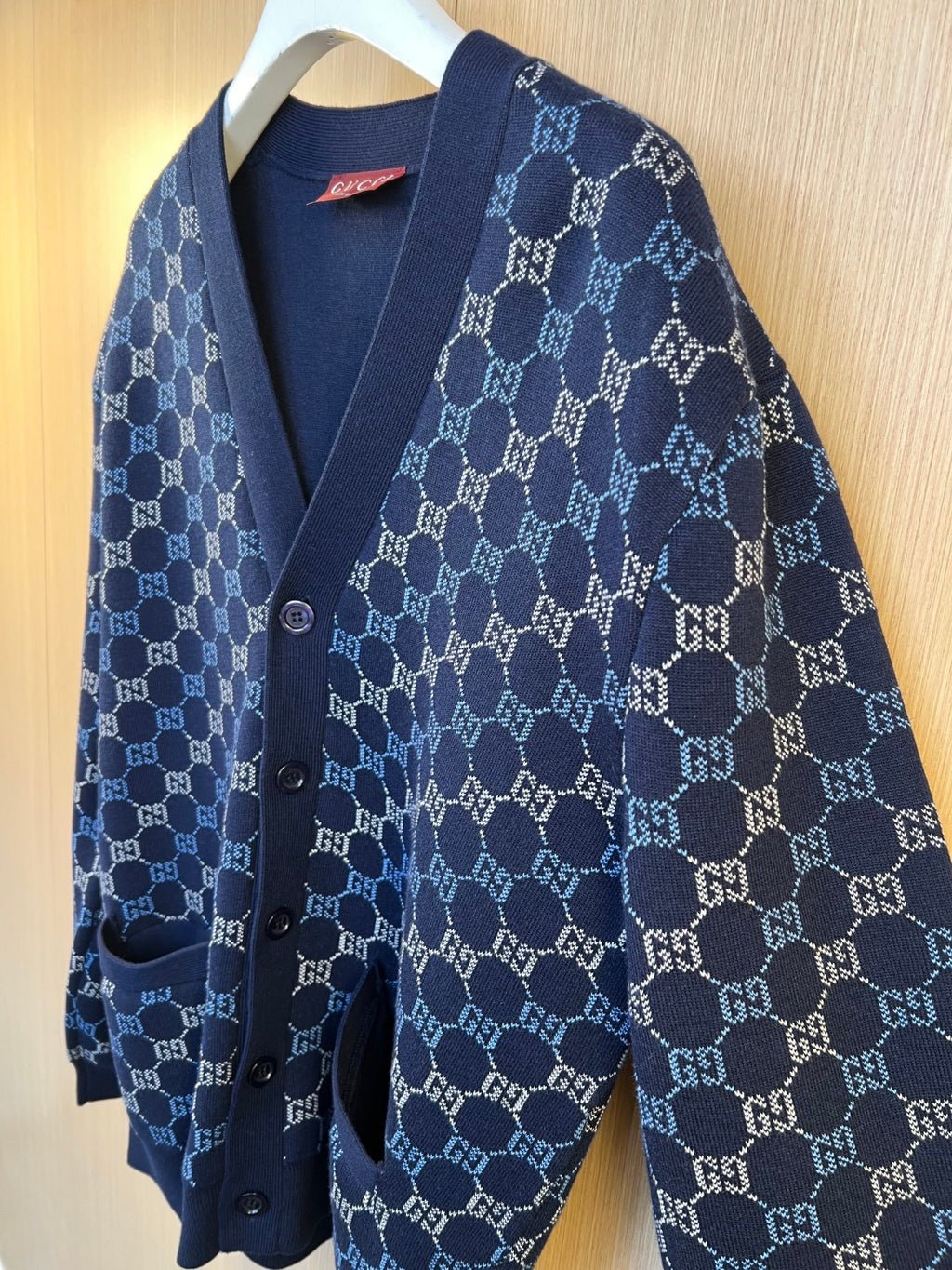 Gucci knit cardigan angled view with navy GG monogram pattern, button-front