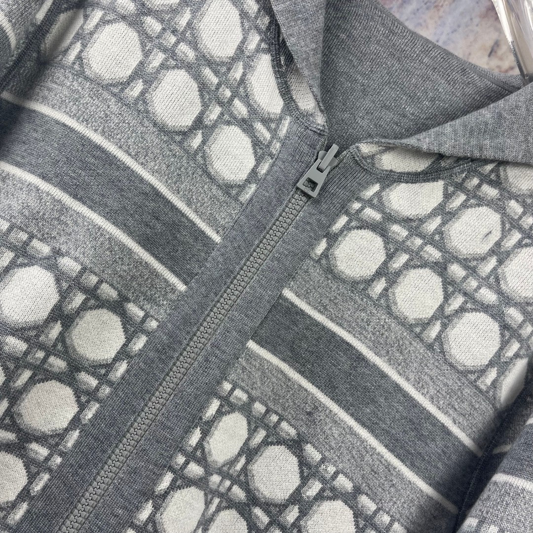 Geometric knit zip hoodie detail on gray fabric with zipper edge