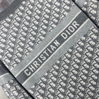 Close-up of Dior logo stripe on gray crewneck sweater, monogram pattern fabric