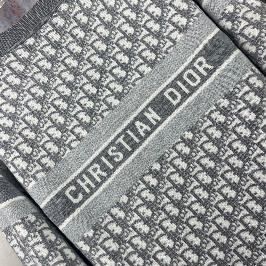 Close-up of Dior logo stripe on gray crewneck sweater, monogram pattern fabric