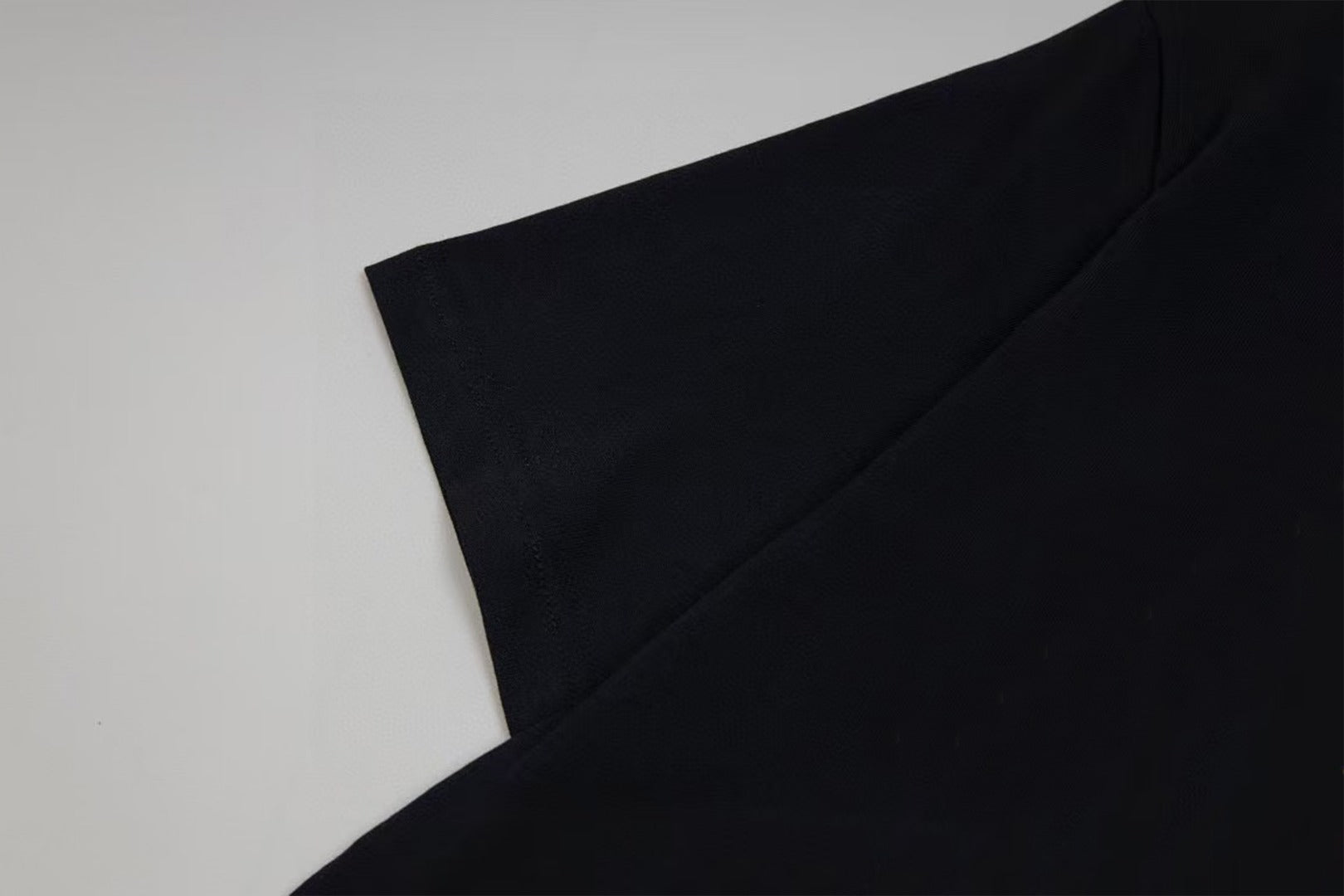 Black short-sleeve T-shirt sleeve and shoulder seam detail