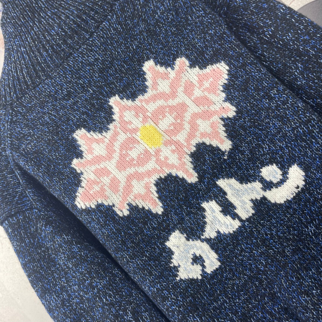 Louis Vuitton navy knit jacket close-up with pink floral and white motif intarsia