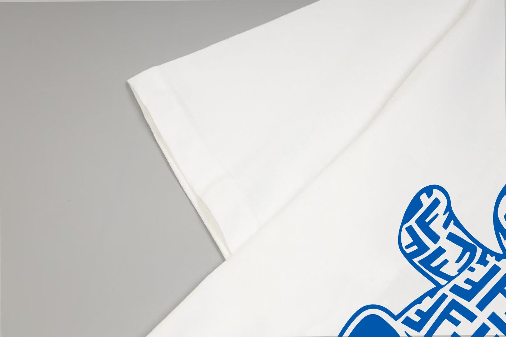 White T-shirt sleeve detail with blue FENDI logo graphic