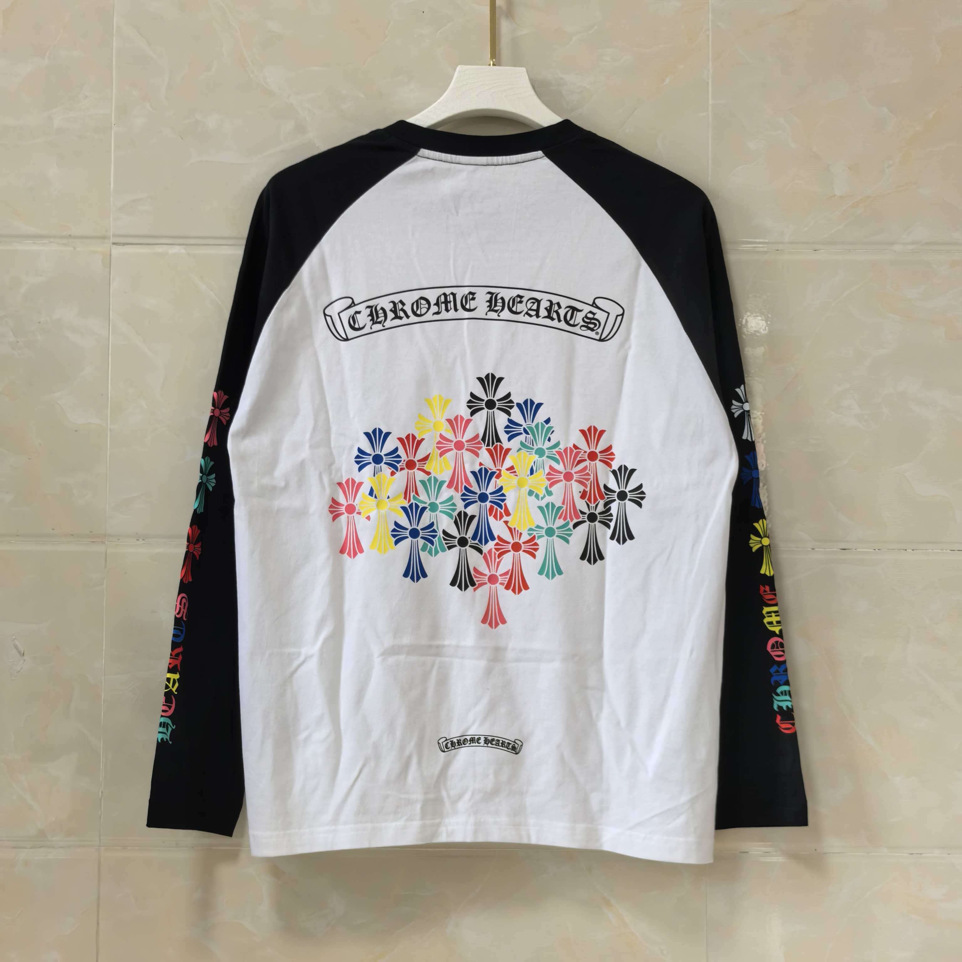 Raglan long-sleeve T-shirt in white and black with colorful floral logo back print.