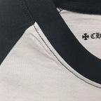 Raglan neckline and sleeve seam with black trim on white T-shirt.