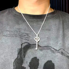 Silver-tone pendant necklace on model with heart G charm and key drop