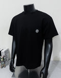 Black short-sleeve T-shirt with crew neck and small circular chest logo patch