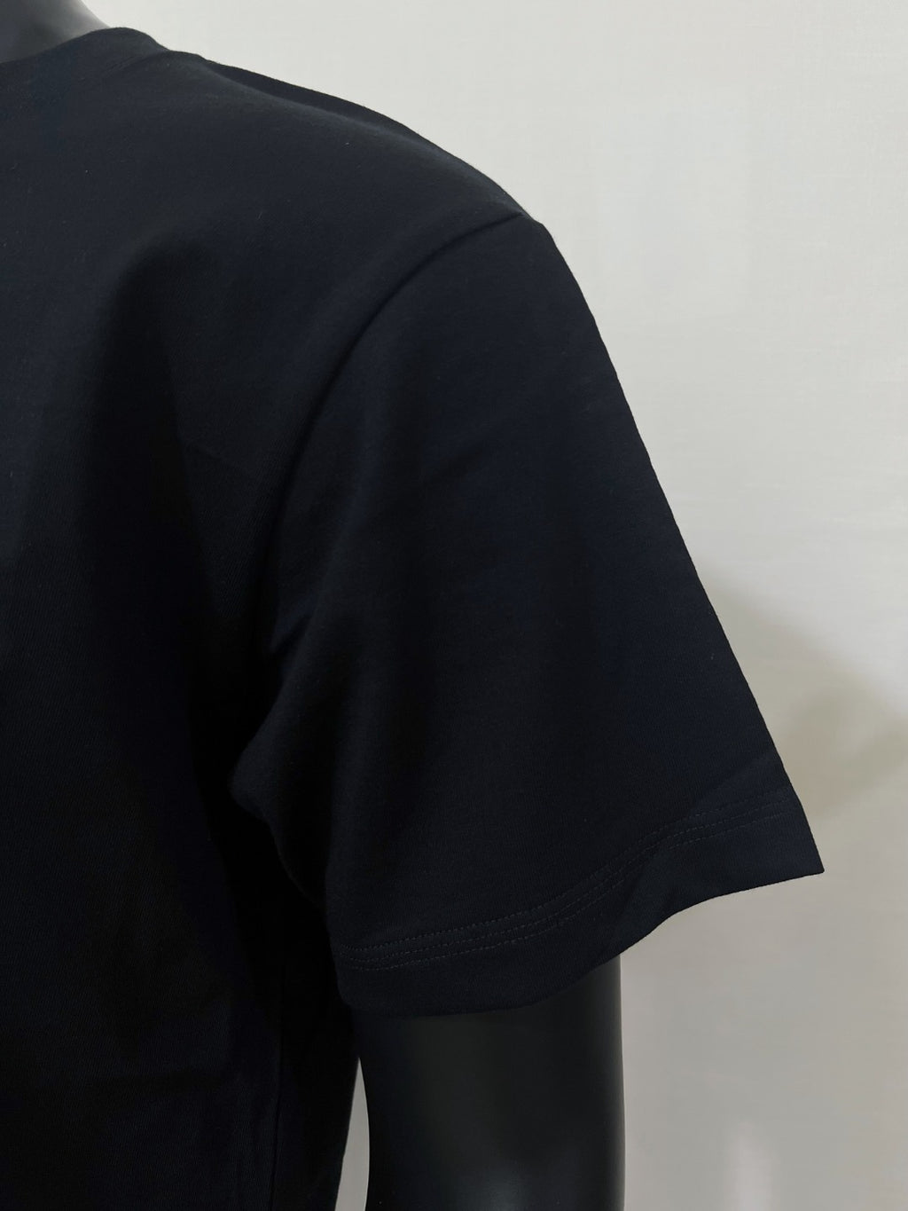 Black T-shirt with short sleeves, angled side view