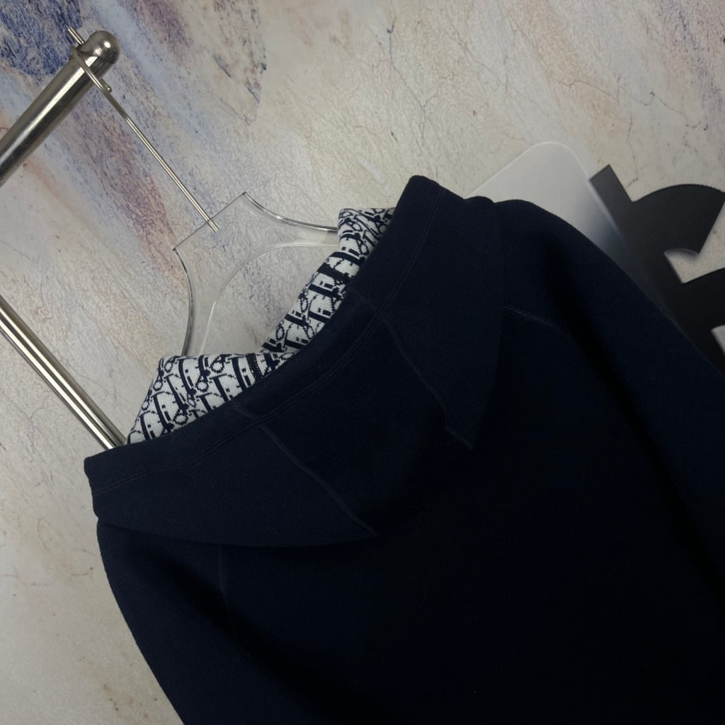 Navy zip-up hooded jacket with black-and-white patterned interior detail